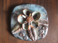 Ukrasna zidna keramika (tirkizni cvijet) na drvenoj podlozi 14 x 14 cm