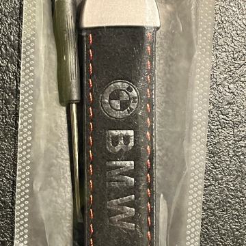 BMW-KOŽNI CRNI PRIVJESAK SA RINGOM OPŠIVEN CRVENIM KONCEM