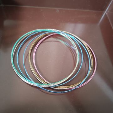 Više tankih šarenih raznobojnih metalnih narukvica - bižuterija