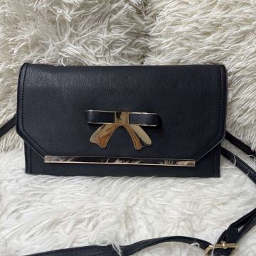 Crna elegantna torbica s naramenicom preko ramena i oko ruke