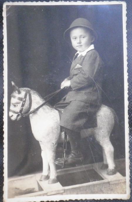 Stara fotografija dječaka na drvenom konjiću